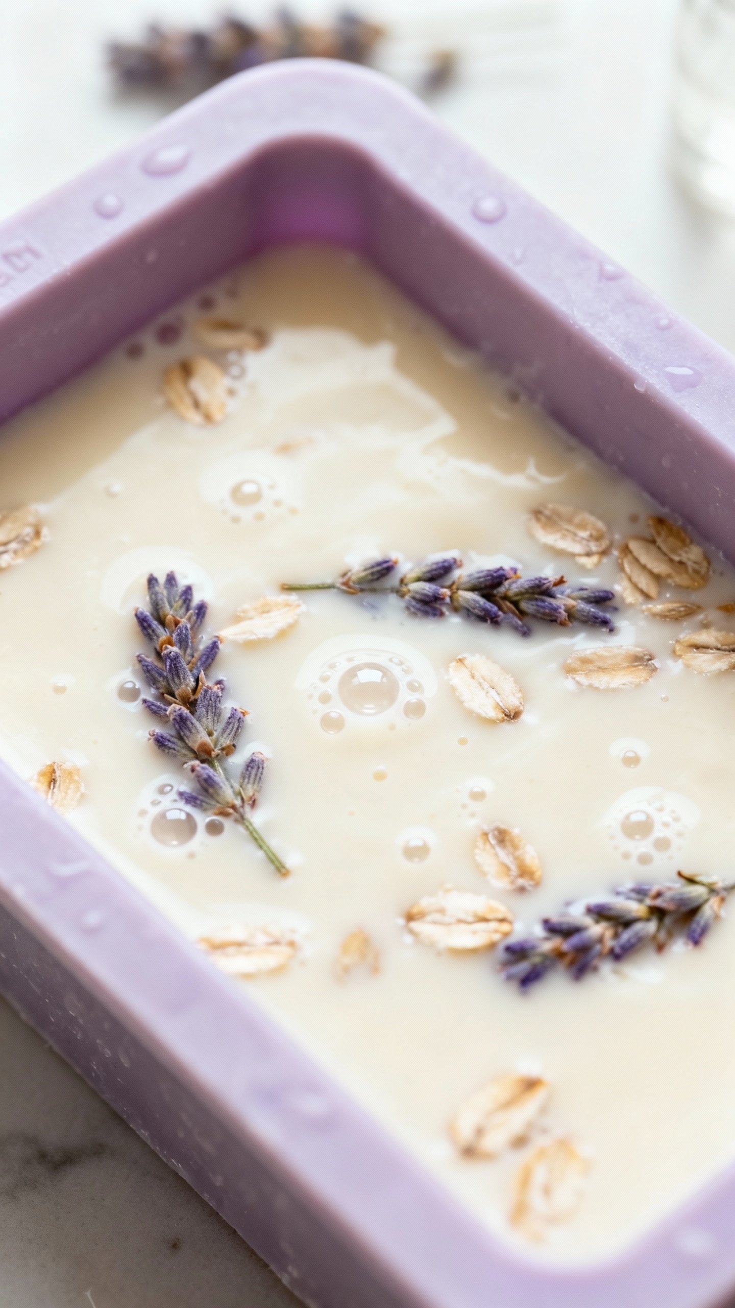 How To Make Soap At Home — Easy Melt & Pour Recipe For Beginners Overhead of silicone soap mold filled with creamy goat milk soap, lavender buds and oatmeal specks,